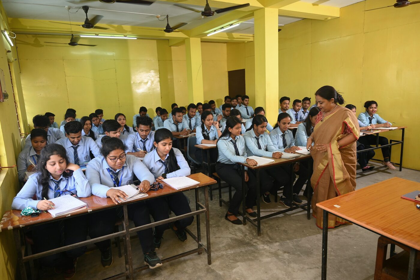A full classroom of students in uniform working at their desks