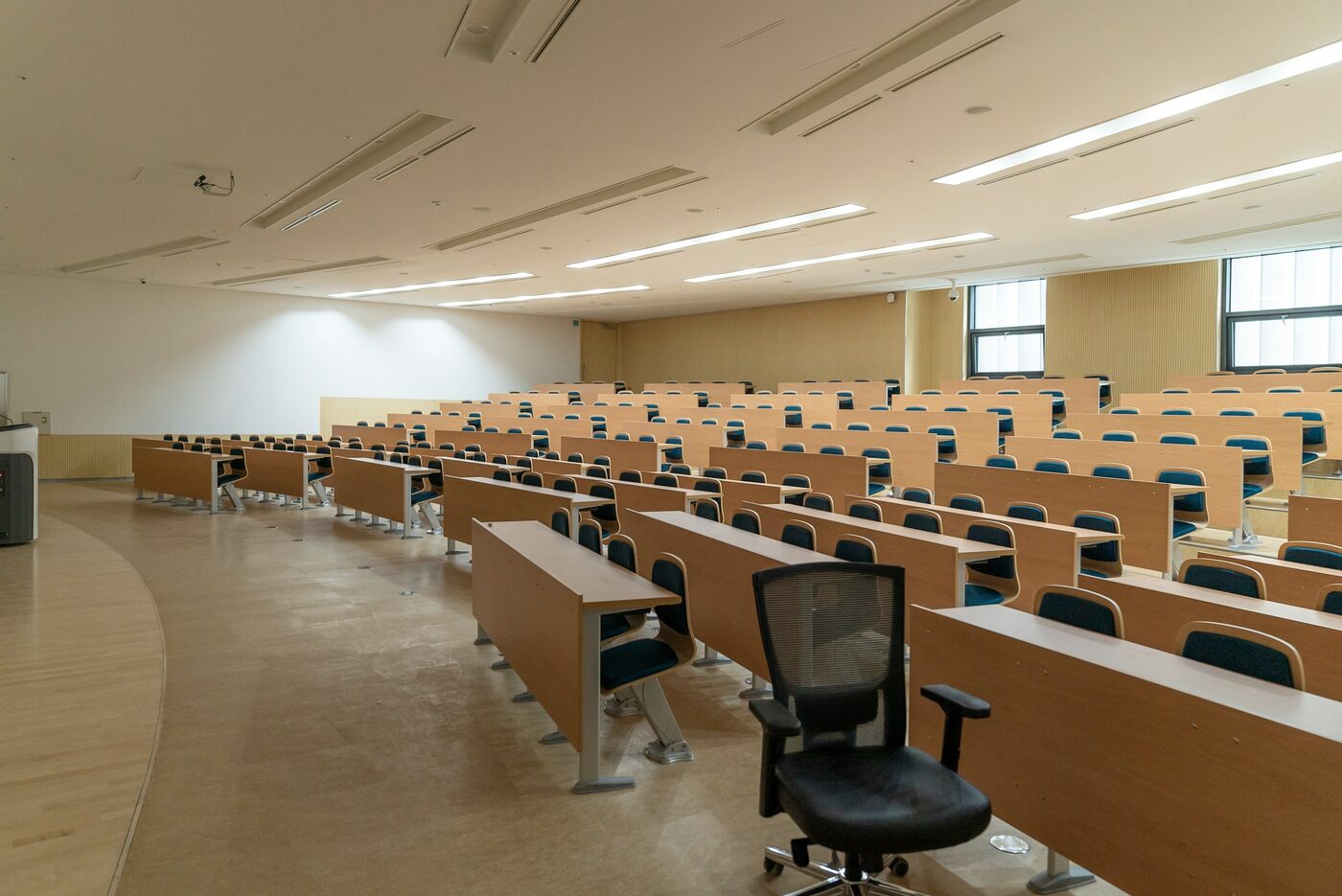 Rows of empty desks in a university lecture hall