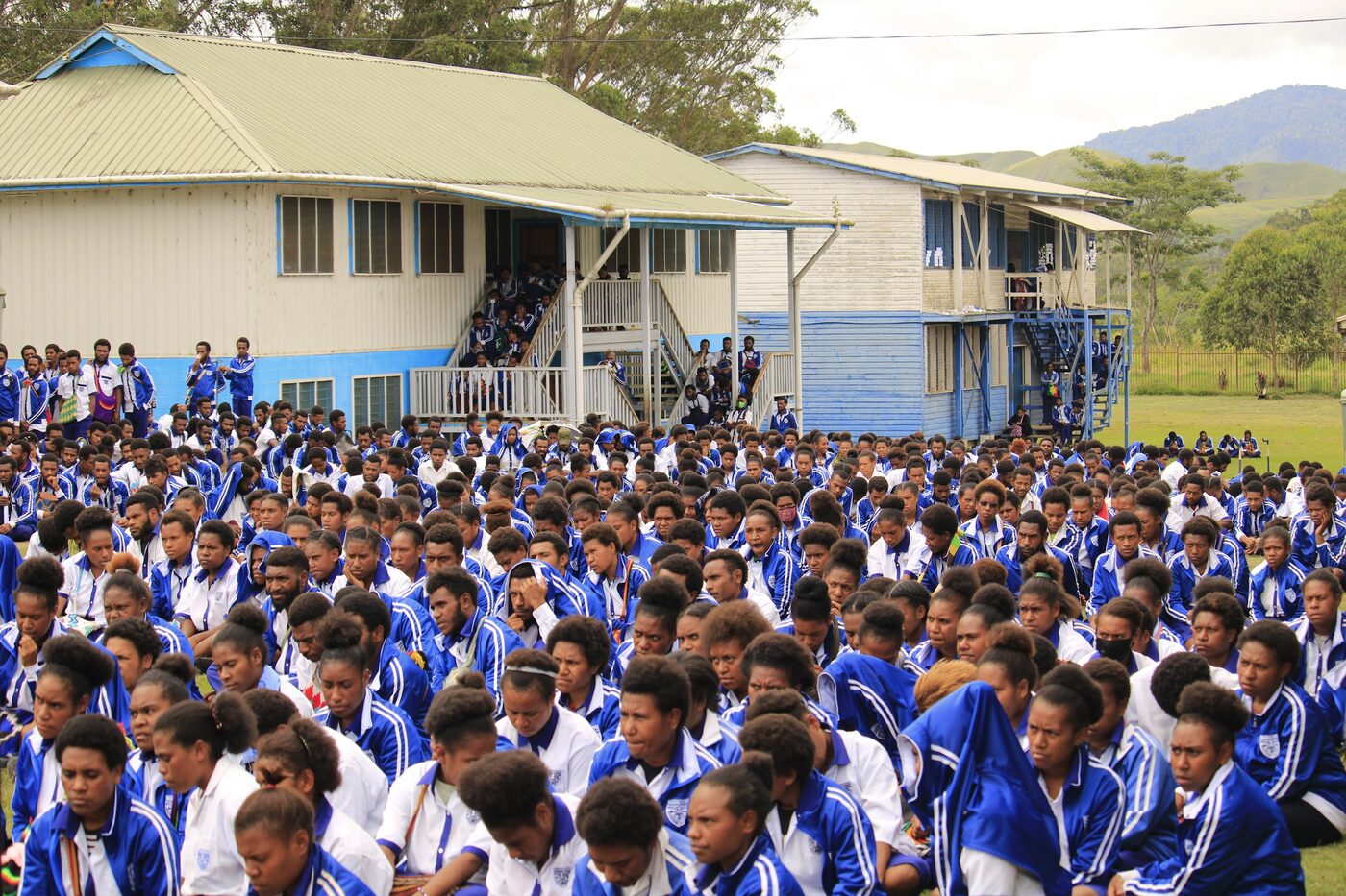 Students in blue uniforms gathered for assembly outside a school in Papua New Guinea